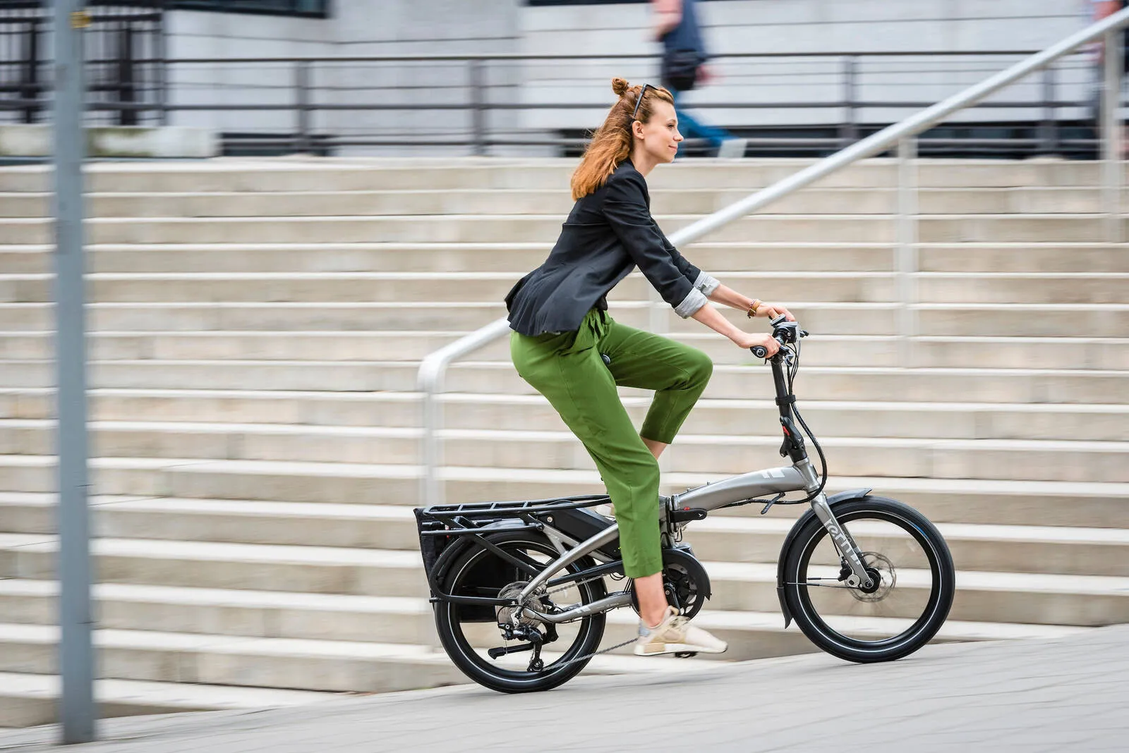 A person riding a Tern Vektron along a street