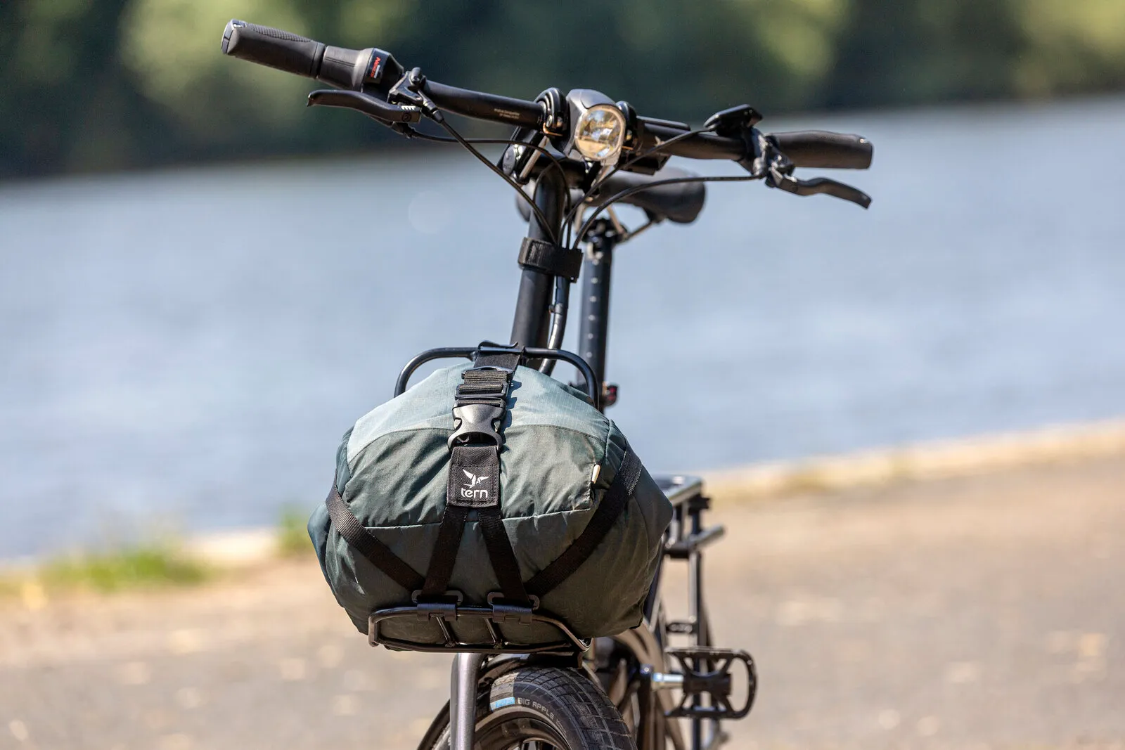 A Tern bag strapped to the Vektron's rear rack on a riverside path.