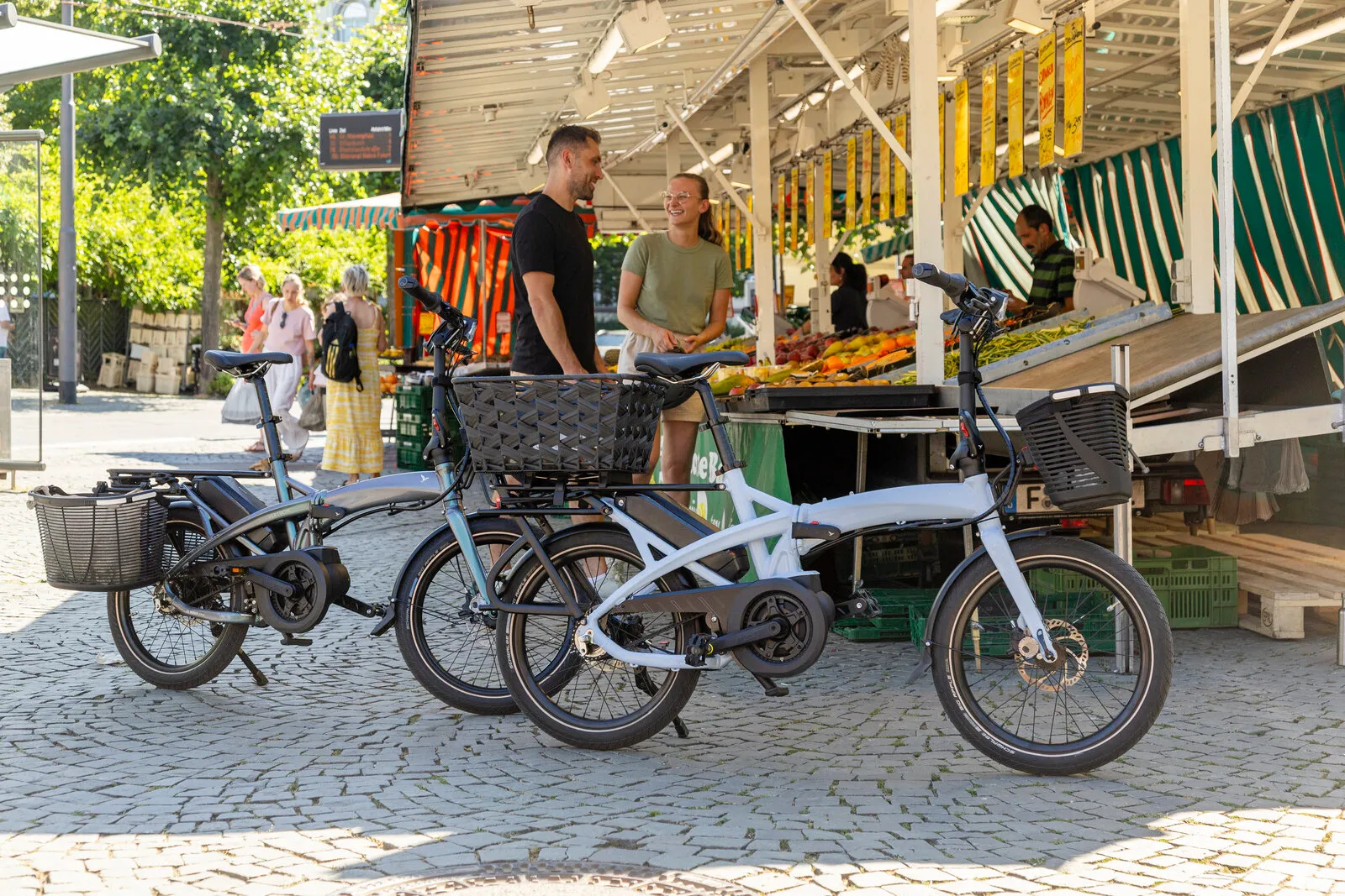 Two Tern Vektrons with front and rear baskets parked at a market stall.