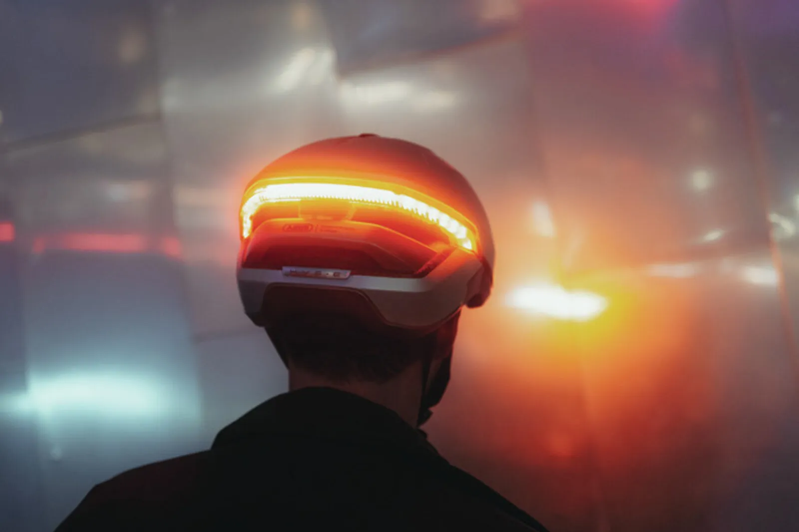 Close-up of rider wearing the ABUS HYP-E BL.ACE in gleam silver, showing the integrated rear light