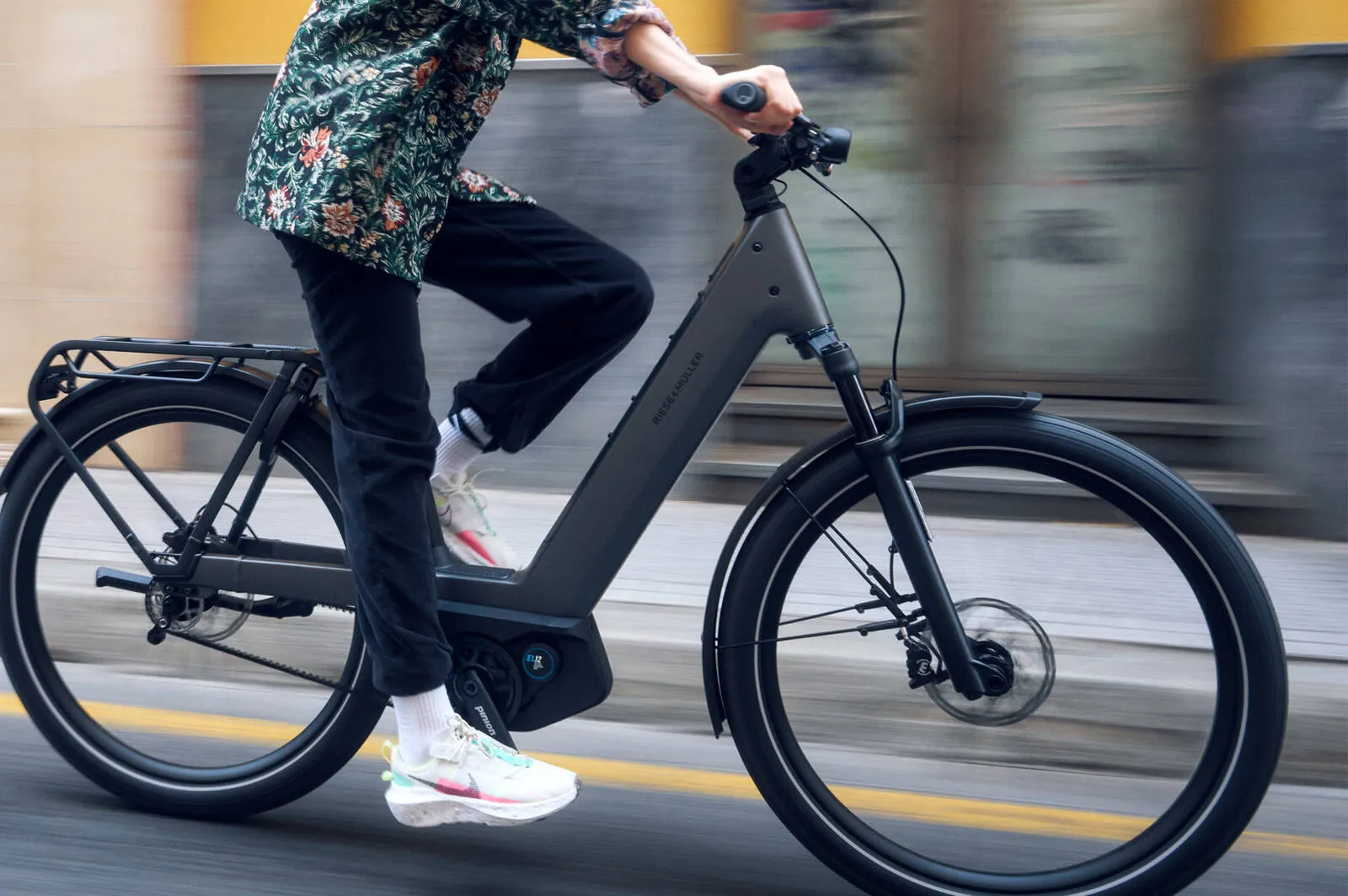 A cyclist riding the Nevo5 pinion through urban streets.