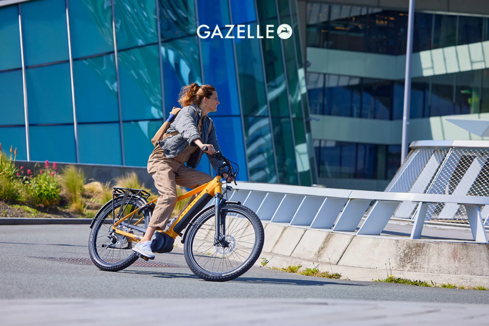 Cyclist riding a Gazelle Medeo e-bike through an urban environment.