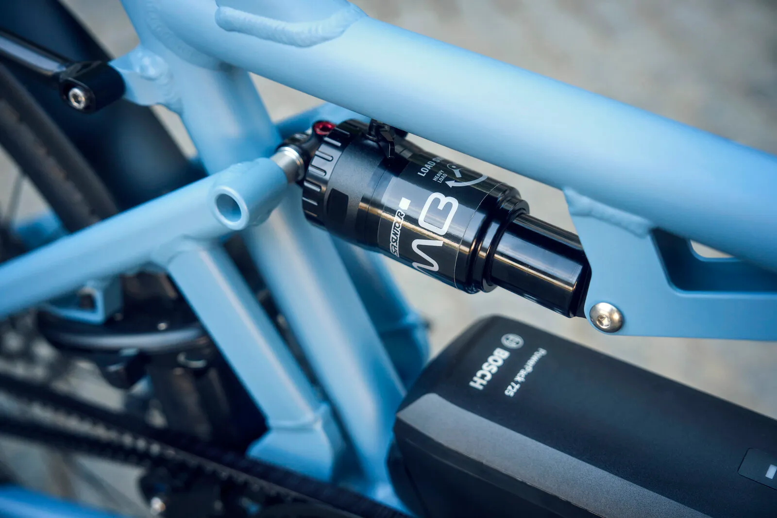 Close-up of the Load5 75 rear suspension shock absorber mounted on the arctic frame, with Bosch battery visible below.