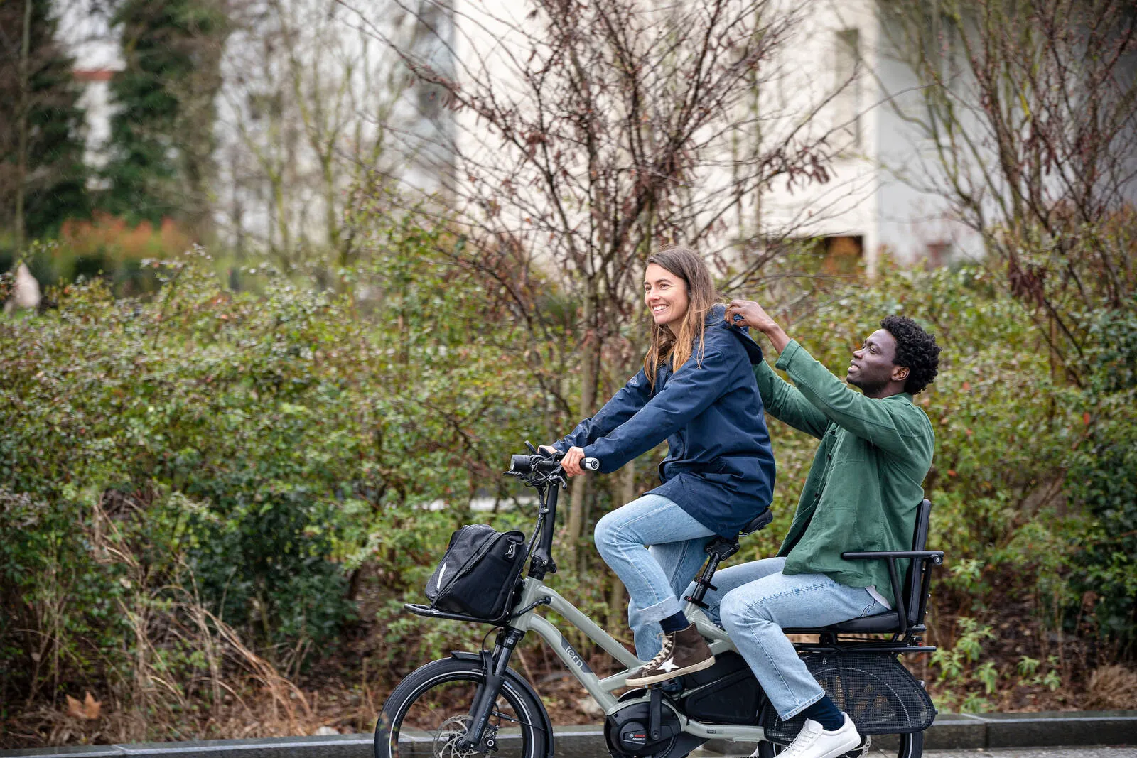 A couple riding their Tern HSD together along a street.