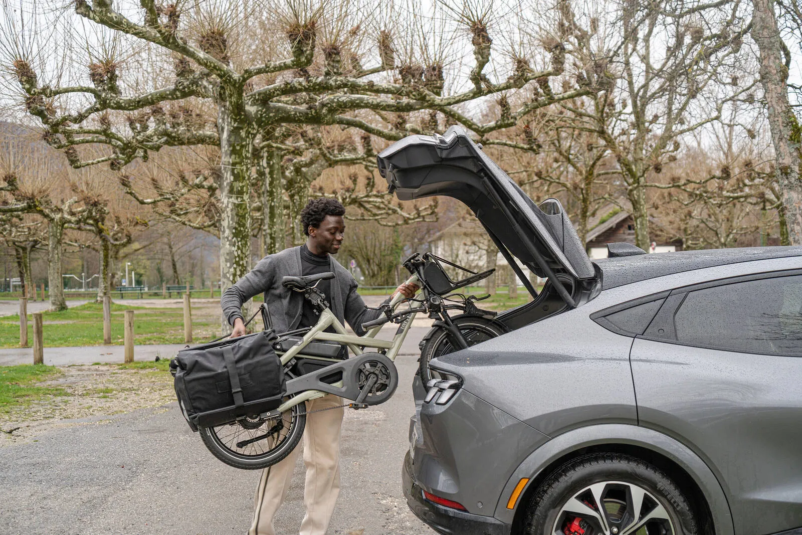 A man putting his Tern HSD in the boot of a car.