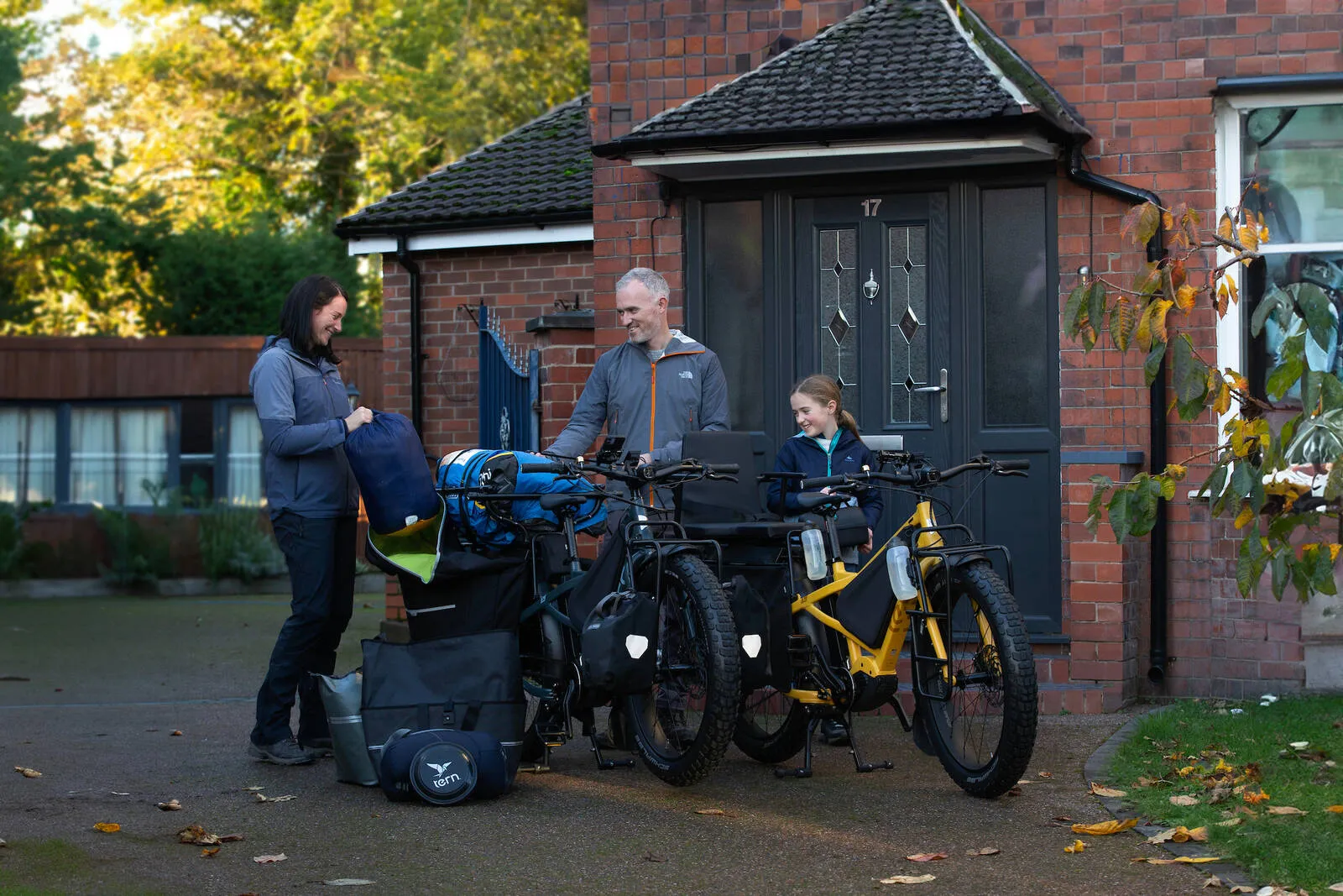 A family with two Tern Orox bikes outside their house preparing for a camping trip