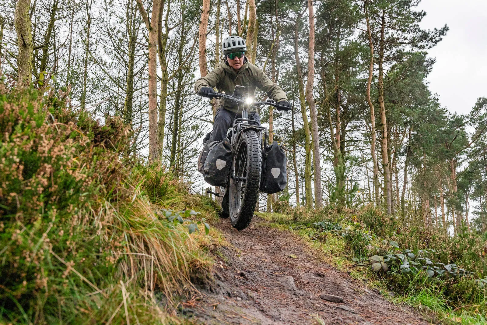 A man riding his Tern Orox down a steep forest trail