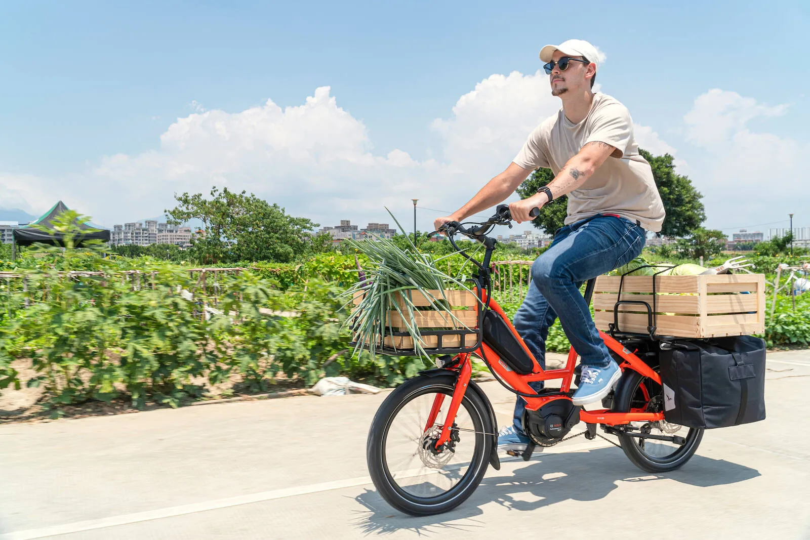 A man riding a Tern Quick Haul loaded up with vegetables