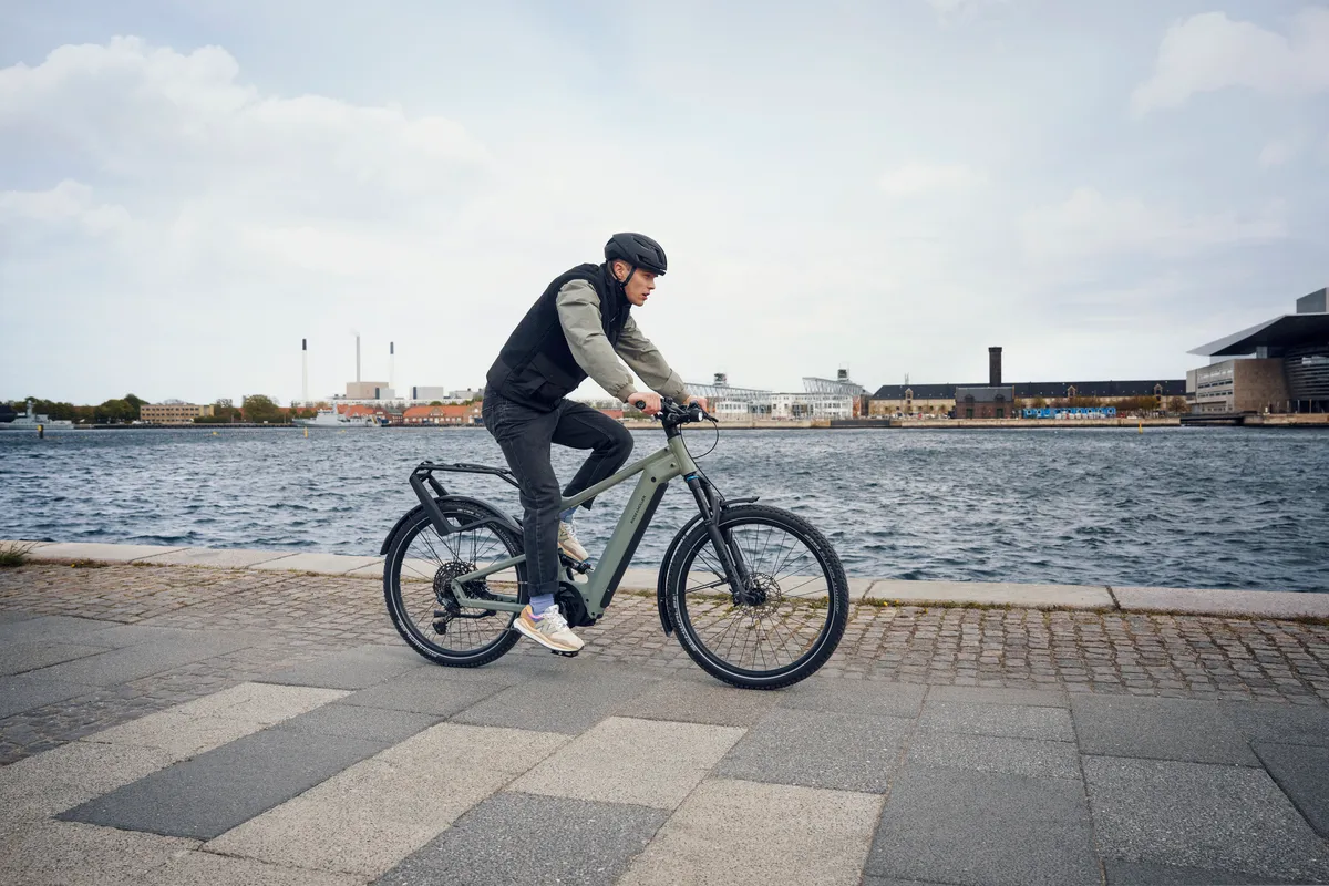 A man riding Riese & Müller’s Delite along a quayside.