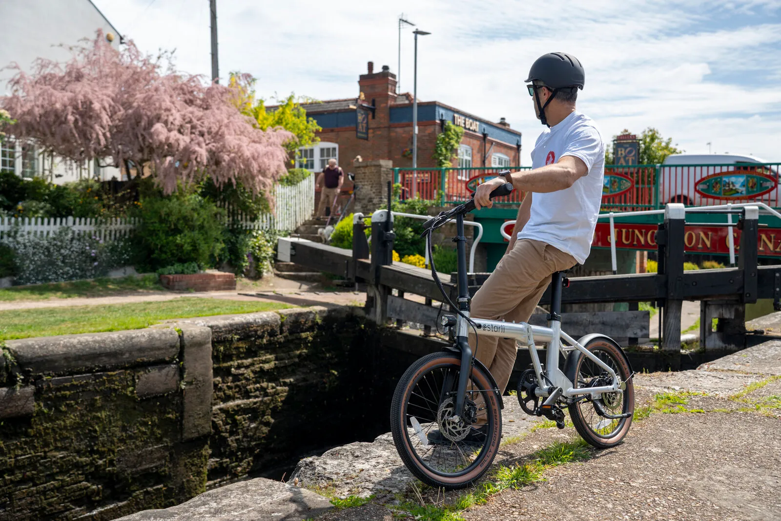 A man with the Estarli e20.X at a canal lock with a pub in the background.