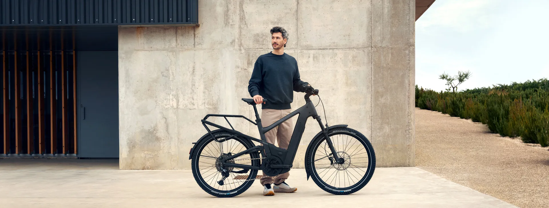 A man standing with a Riese & Müller Multicharger outside a modern concrete building