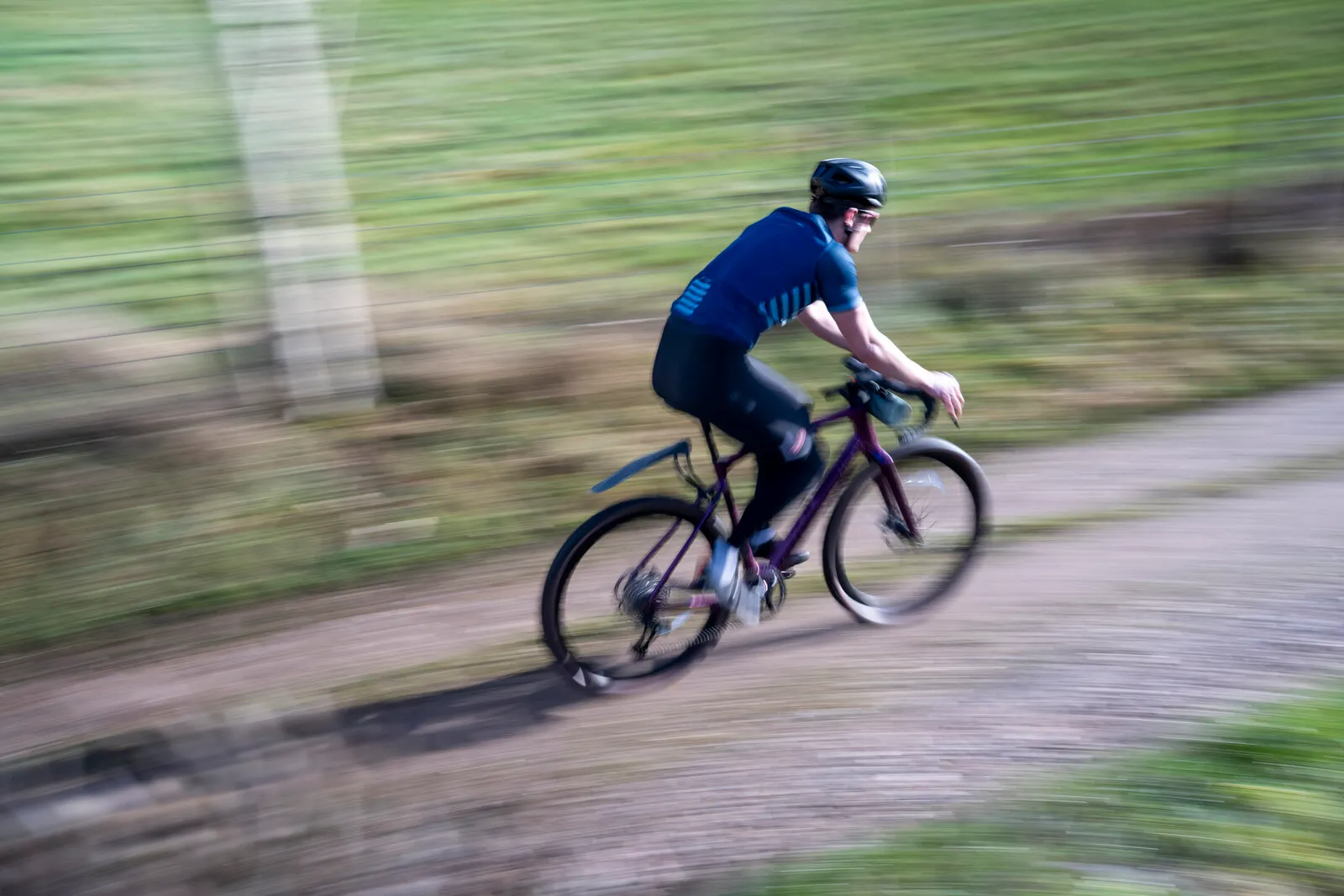 A rider descending a gravel track on an Estarli G700 fitted with mudguards.