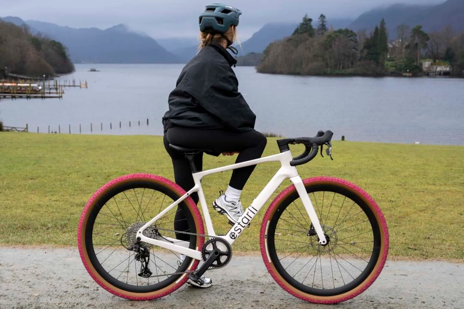 A woman on a lunar white Estarli G700 pausing to look out over a lake.