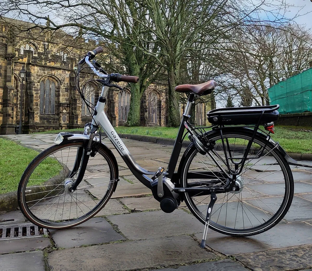 A Gazelle Orange e-bike parked outside the Lancaster Priory on a bright winter’s day