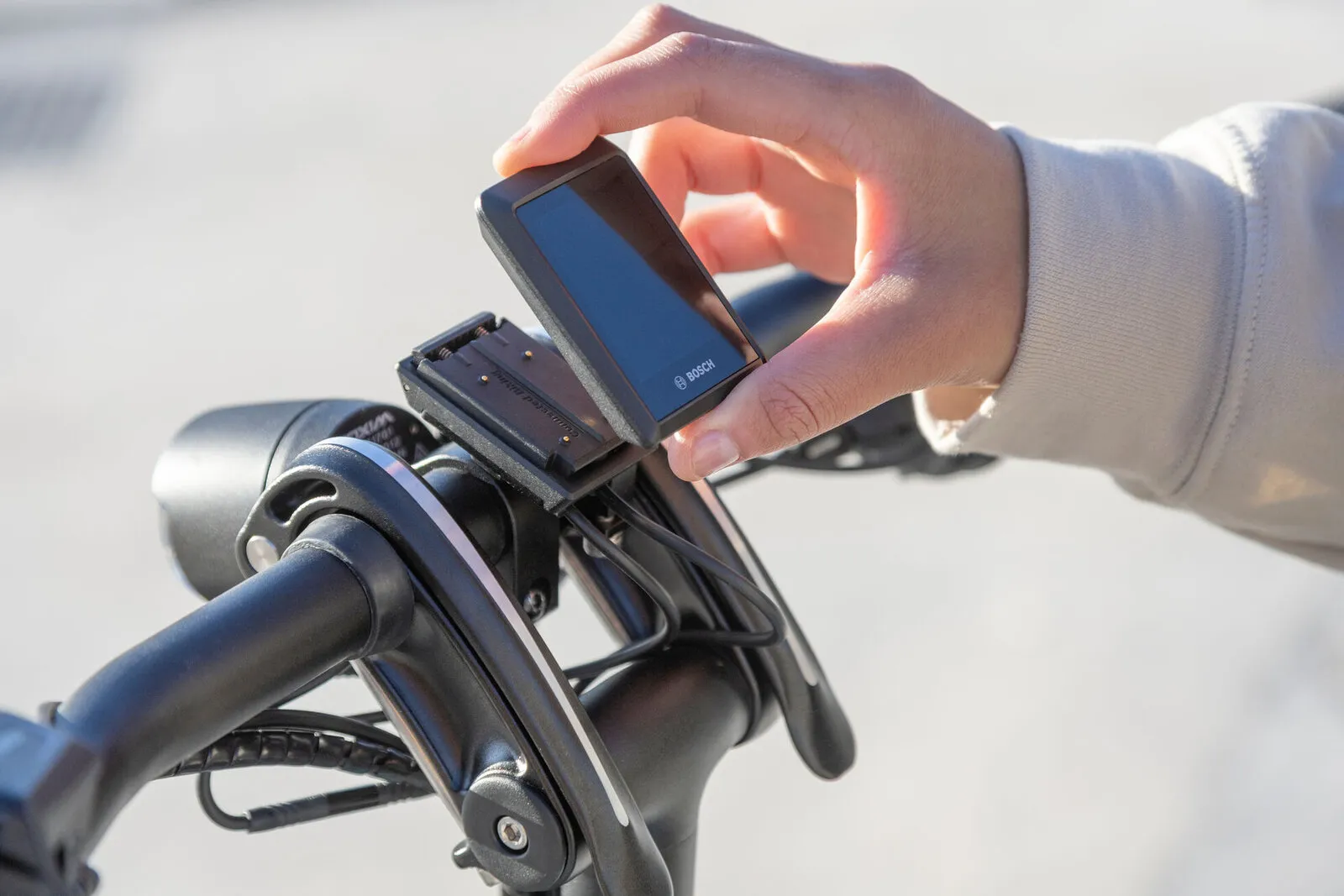 A rider clipping a Bosch display onto the handlebar mount of a Tern GSD.