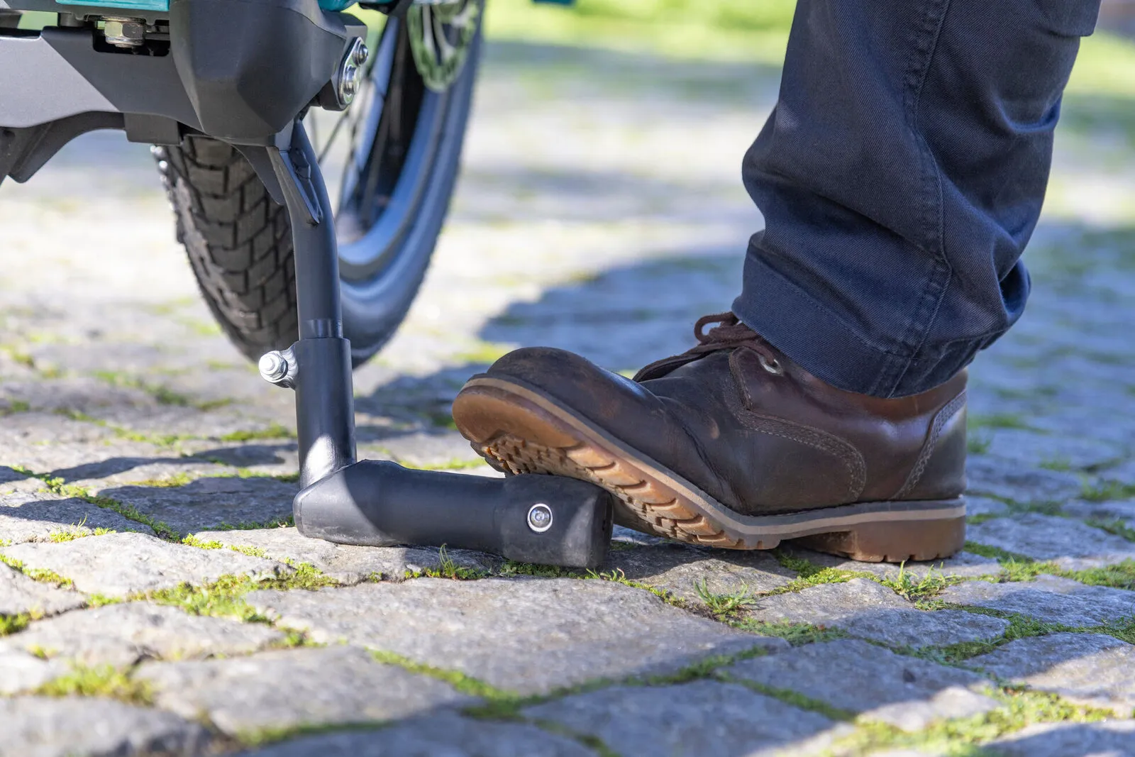 A rider pushing down the Atlas Lockstand of a Tern GSD with their foot.