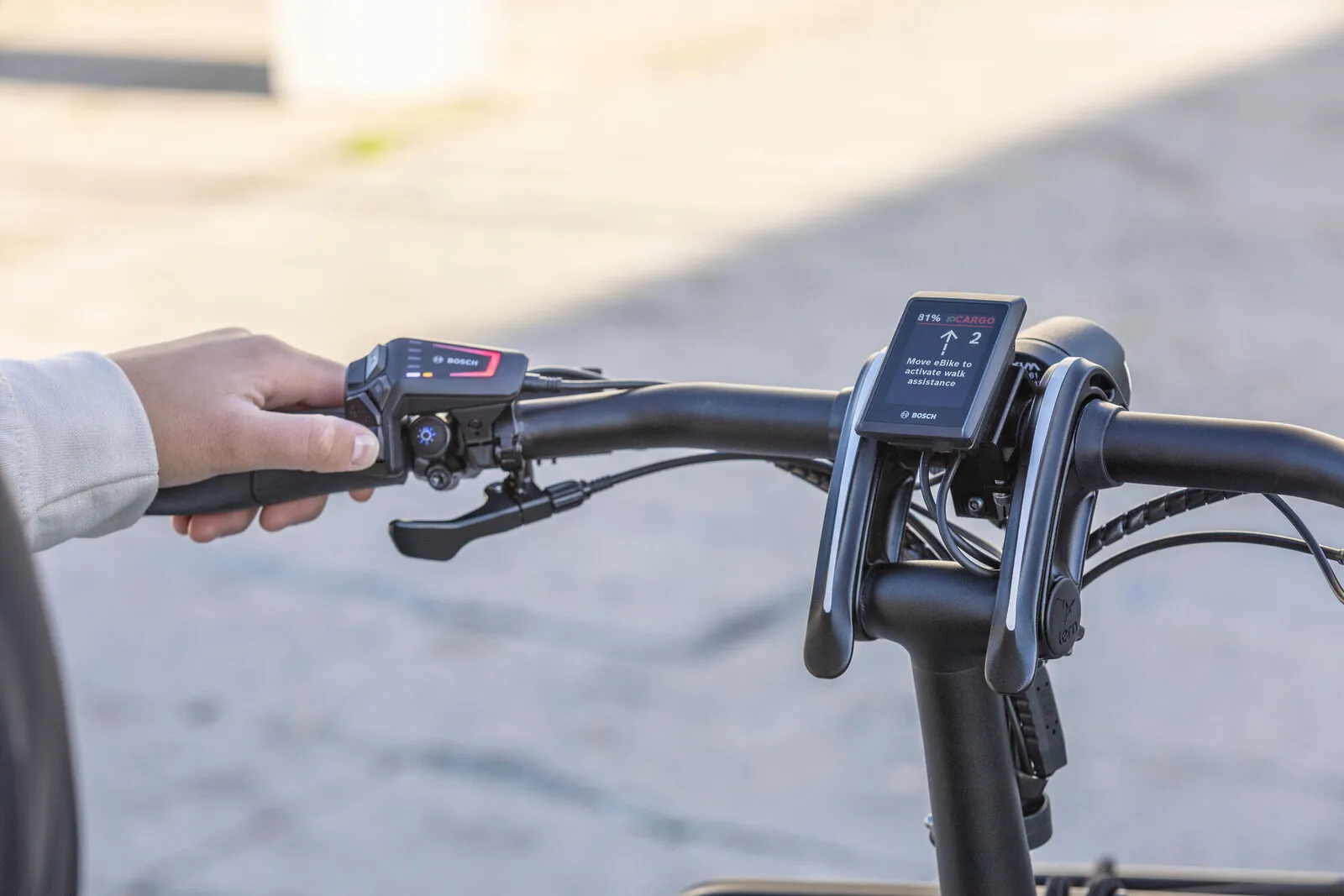 A rider's hands on the Bosch LED remote and Kiox 300 display of a Tern GSD.