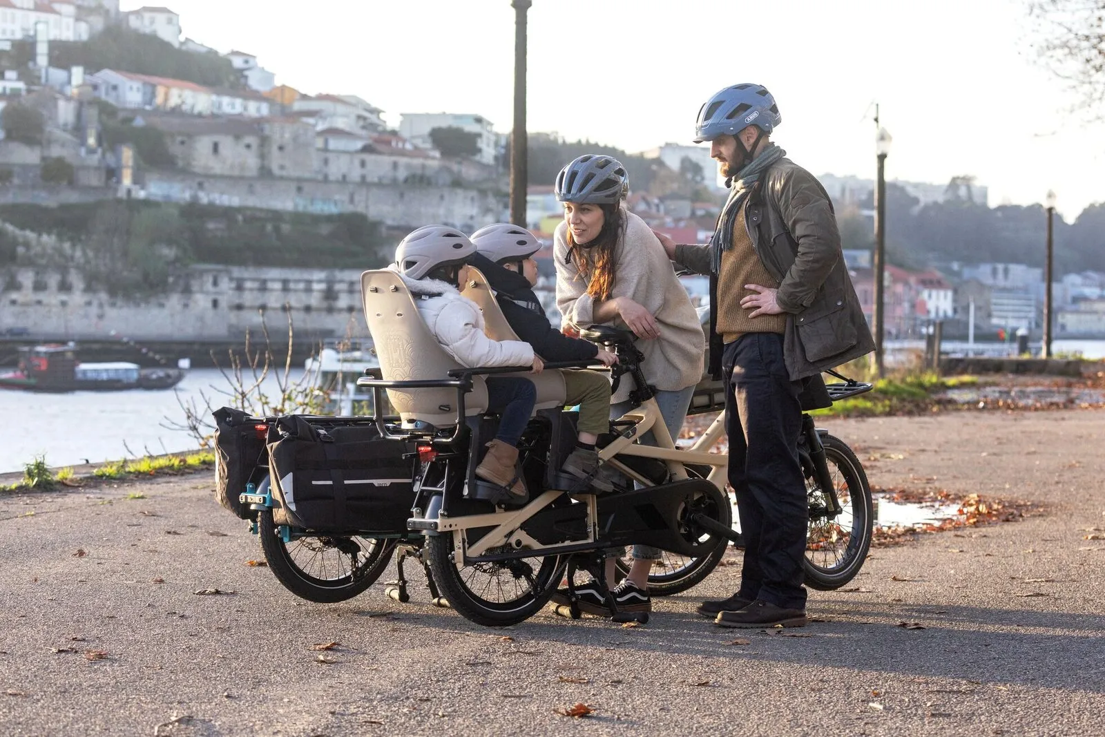 A family standing beside a satin beige Tern GSD by a river, with two children in the Clubhouse seats.