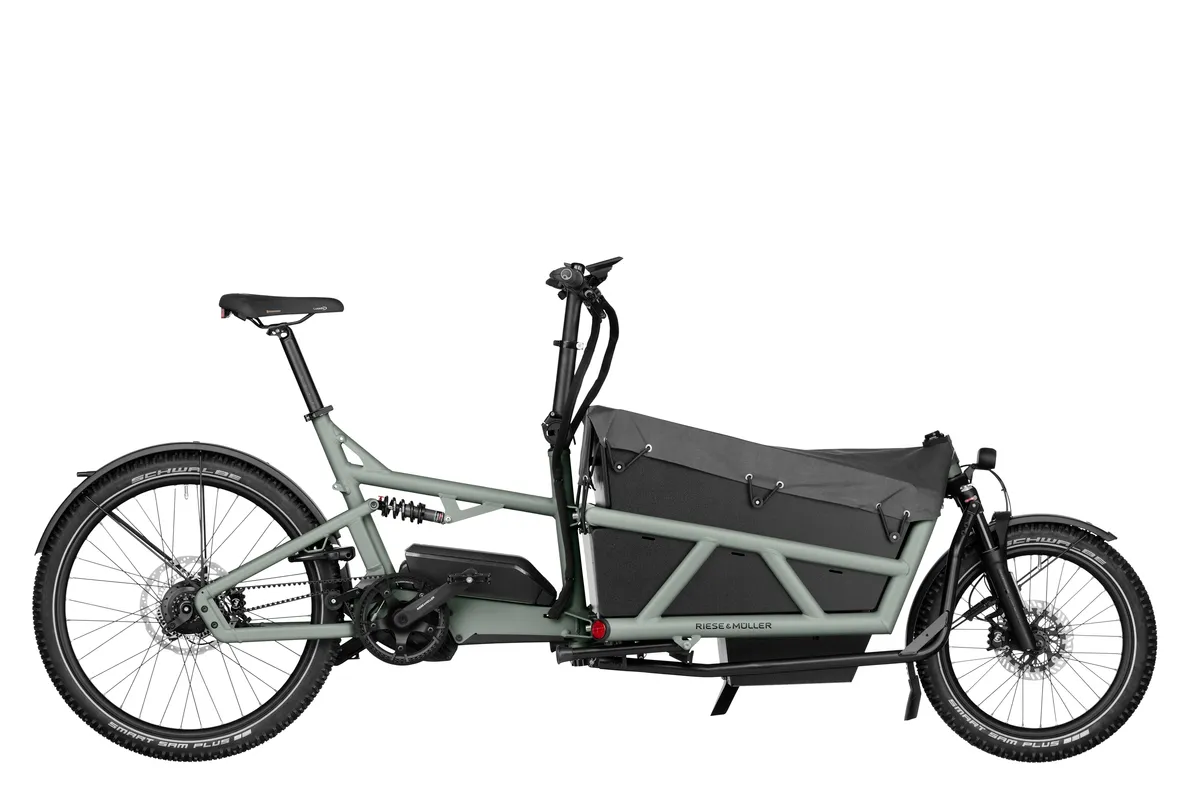 Riese & Müller Load4 75 in coal grey matt with low side walls and three child seats with a footwell.