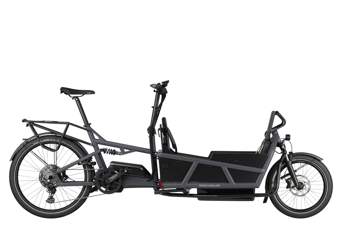 Riese & Müller Load4 75 in coal grey matt with a rear rack, low side walls and three child seats with a footwell.