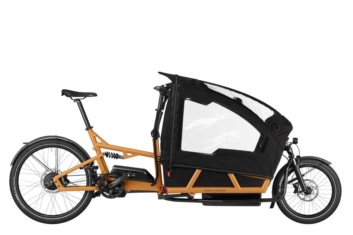 Riese & Müller Load4 75 in peanut matt with low side walls, a child cover and three child seats with a footwell.