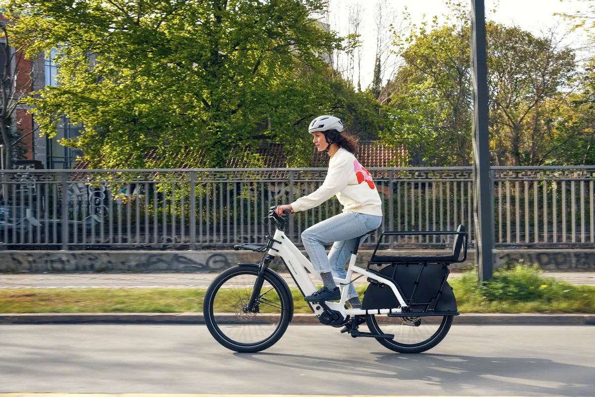 A lady riding a Riese & Müller Multicharger2 along a clear road.