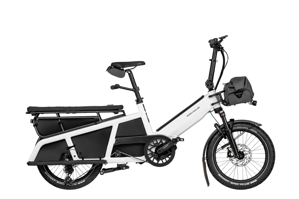 Riese & Müller Multitinker touring in pearl white/black with passenger kit and front bag.