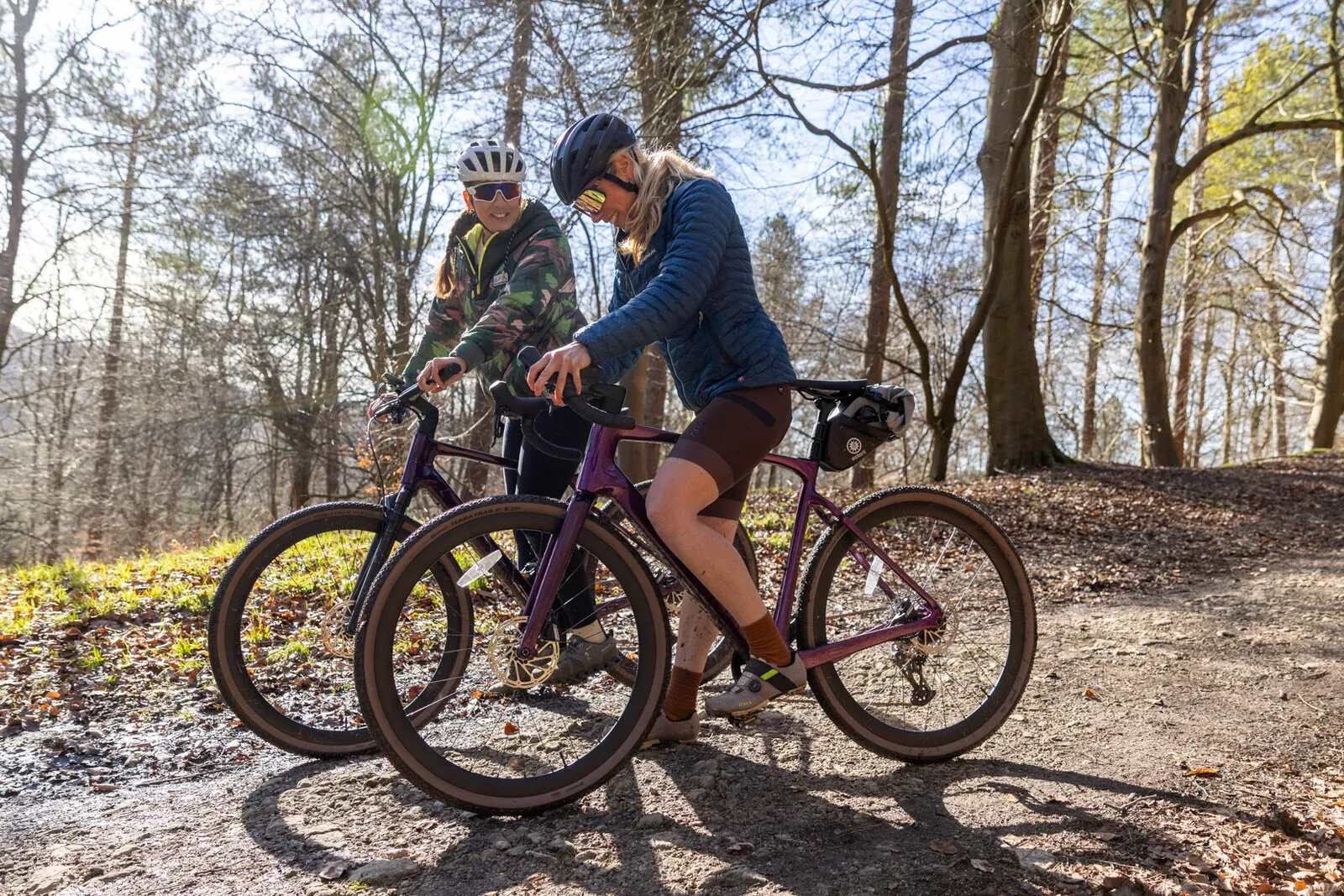Two riders pausing on a woodland track with their Estarli gravel bikes.